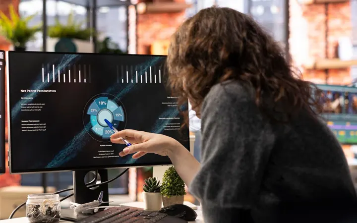 Analyst reviewing data dashboards on screens